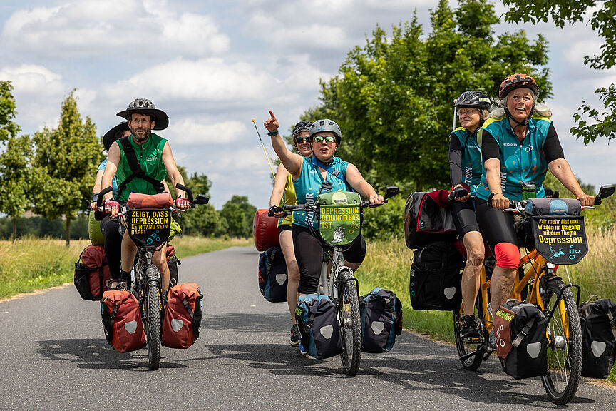 Mit dem Tandem auf Mut-Tour Drei Tandems mit Radfahrerinnen und Radfahrer radeln auf einer Landstraße.