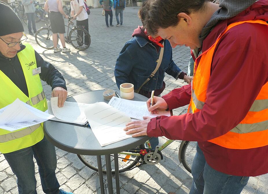 Fleißige Helfer Zwei ADFC-Helfer stehen am Stand und füllen Listen aus