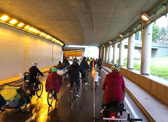 Fahrradfahrer fahren während der Demo durch einen Tunnel.